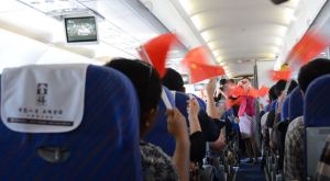 Narda singing something about we wish you well China to the tune of happy birthday. She is somewhere behind the crew and flag wavers.