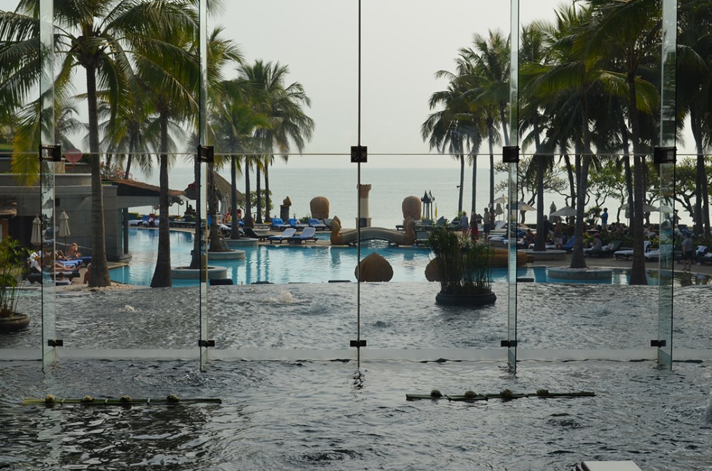 The lobby of the Hilton Hotel with water falls into a pool and on into the sea