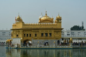 Sri Harmandir Sahib ("The abode of God"), also known as Darbar Sahib, (Punjabi pronunciation: [dəɾbɑɾ sɑhɪb]),[2] [3] informally referred to as the Golden Temple,[2] is a Gurdwara located in the city of Amritsar, Punjab, India. It is one of the most revered spiritual sites of Sikhism. Amritsar (literally, the tank of nectar of immortality) was founded in 1577 by the fourth Sikh guru, Guru Ram Das.[4] The fifth Sikh Guru, Guru Arjan, designed Harmandir Sahib to be built in the center of this tank, and upon its construction, installed the Adi Granth, the holy scripture of Sikhism, inside Harmandir Sahib.[2] The Harmandir Sahib complex is also home to the Akal Takht (the throne of the timeless one, constituted by the Sixth Guru, Guru Hargobind). While the Harmandir Sahib is regarded as the abode of God's spiritual attribute, the Akal Takht is the seat of God's temporal authority.[5] The construction of Harmandir Sahib was intended to build a place of worship for men and women from all walks of life and all religions to worship God equally.[2][6] The four entrances (representing the four directions) to get into the Harmandir Sahib also symbolise the openness of the Sikhs towards all people and religions.[7] Over 100,000 people visit the shrine daily for worship, and also partake jointly in the free community kitchen and meal (Langar) regardless of any distinctions, a tradition that is a hallmark of all Sikh Gurdwaras.